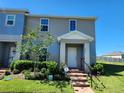 Charming two-story home with landscaped yard, brick pathway, and covered entrance at 474 Annabelle Way, Davenport, FL 33837