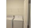 Laundry room features white washer, dryer, and wire shelving for storage at 4881 Vellacito Way, Davenport, FL 33897