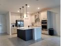 Bright kitchen with stainless steel appliances, island with breakfast bar, and modern pendant lighting at 4952 Shady Pines Dr, St Cloud, FL 34772