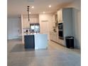 Bright open-concept kitchen with stainless steel appliances, island with breakfast bar, and tile flooring at 4952 Shady Pines Dr, St Cloud, FL 34772