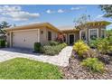 Charming single-story home boasts a two-car garage, stone walkway, and mature landscaping for curb appeal at 531 Barcelona Dr, Poinciana, FL 34759