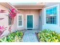 Inviting front entryway featuring a teal door, brick path, and lush landscaping at 531 Barcelona Dr, Poinciana, FL 34759