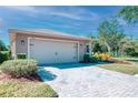 Two-car garage with brick-paved driveway and manicured bushes at the front of a single-story home at 531 Barcelona Dr, Poinciana, FL 34759