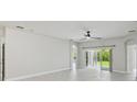 Bright living room features tile floors, neutral paint, modern ceiling fan, and sliding glass doors at 531 Barcelona Dr, Poinciana, FL 34759