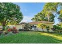 Beautiful exterior of a well-kept home with lush landscaping, featuring tropical plants and a vibrant green lawn at 541 Rebecca Dr, St Cloud, FL 34769