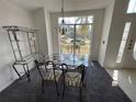 Bright dining room boasts stylish decor, a glass table, and a large window with scenic views at 642 Riggs Cir, Davenport, FL 33897