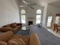 Spacious living room featuring a vaulted ceiling, fireplace, and ample natural light at 642 Riggs Cir, Davenport, FL 33897