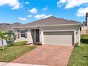 Inviting single-story home with landscaped front yard and brick-paved driveway at 709 Blackstone St, Minneola, FL 34715