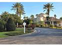 Beautiful clubhouse with manicured landscaping, palm trees, and a roundabout driveway at 7240 Westpointe Blvd # 1122, Orlando, FL 32835