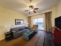 Comfortable living room with couch, chair, and balcony access showcasing ocean view at 8125 Resort Village Dr # 5310, Orlando, FL 32821