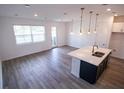 Stylish open floorplan with bright kitchen, an island with a sink, and modern pendant lighting at 947 Conch Rd, Davenport, FL 33896