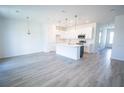 Bright, open-concept kitchen features white cabinets, stainless steel appliances, and a large island at 947 Conch Rd, Davenport, FL 33896