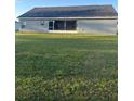The backyard has lush lawn, a large sliding glass door, and ample room for outdoor activities and relaxation at 11115 Sw 54Th Cir, Ocala, FL 34476