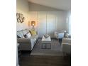 Well-lit living room with stylish decor, comfortable seating, decorative mirror, and a patterned rug at 11115 Sw 54Th Cir, Ocala, FL 34476