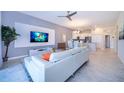 Bright living room with sleek white furniture, tile floors, and an open layout connected to the modern kitchen at 1137 Drop Ln # 1137, Davenport, FL 33896