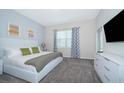 Cozy bedroom featuring a comfortable bed, stylish curtains, and a modern dresser with a mounted television at 1137 Drop Ln # 1137, Davenport, FL 33896
