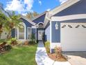 Beautiful home exterior showcasing manicured lawn, white trim, and a lovely blue facade at 13223 Meadowlark Ln, Orlando, FL 32828
