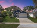 Charming single-story home with a manicured lawn and mature landscaping, painted in pleasing, modern colors at 13223 Meadowlark Ln, Orlando, FL 32828