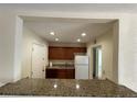 Open kitchen featuring granite countertops, white refrigerator, and wood cabinetry at 1916 Conway Rd # 11, Orlando, FL 32812