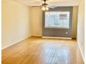 Bright living room features hardwood floors, a ceiling fan and a large window at 1916 Conway Rd # 11, Orlando, FL 32812