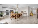 Open floor plan showcasing a kitchen with white cabinets and stainless steel appliances, adjacent to a dining area at 204 Taft Dr, Davenport, FL 33837