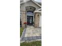 Close up of the front door showcasing the decorative glass door, wreath, brick pillar and paver walkway at 205 Lexingdale Dr, Orlando, FL 32828