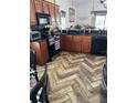 Cozy kitchen features wood cabinets, black countertops, modern appliances, and stylish herringbone flooring at 205 Lexingdale Dr, Orlando, FL 32828
