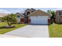 Inviting single Gathering home showcasing well-manicured lawn, 2 car garage, and mature landscaping at 2150 Flintlock Blvd, Kissimmee, FL 34743