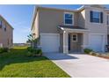 Well-manicured lawn and landscaping surround this two-story home with attached garage at 2188 Tay Wes Dr, St Cloud, FL 34771
