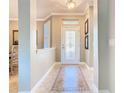 Inviting foyer boasts decorative tile flooring and a glass-paneled front door at 228 Sorrento Rd, Poinciana, FL 34759