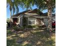 Charming single-story home featuring a landscaped front yard and neutral exterior paint, set beneath palm trees and a blue sky at 2917 Kokomo Loop, Haines City, FL 33844