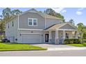 Charming two-story house featuring a gray exterior, manicured lawn, and a two-car garage at 3010 Camden Way, Davenport, FL 33837