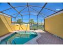 Enclosed spa features a screened-in enclosure, brick patio, and lovely views of the pond at 3101 Yellow Lantana Ln, Kissimmee, FL 34747