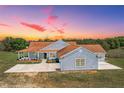 Well-maintained one-story home with a shingle exterior and an expansive driveway at 41636 Outlaw Ln, Weirsdale, FL 32195