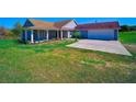 Lovely home with a covered porch, attached garage, and neatly landscaped front yard at 41636 Outlaw Ln, Weirsdale, FL 32195