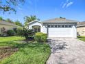 Charming single-story home with a brick driveway and a well-maintained two-car garage at 439 Madera Pass, Poinciana, FL 34759