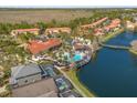 Aerial view of community pool, clubhouse, and surrounding homes near a lake at 4692 Sw Golden Beach N Ct, Kissimmee, FL 34746