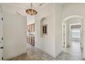 Inviting hallway with neutral walls, decorative niche, and tiled flooring leading to various rooms at 782 Vineyard Way, Poinciana, FL 34759
