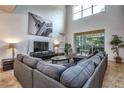 Bright living room with high ceilings, a large sectional sofa, and access to the outdoor patio at 8945 Cuban Palm Rd, Kissimmee, FL 34747