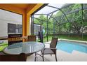 Enclosed patio features a dining area, a small pool, and lush greenery at 8945 Cuban Palm Rd, Kissimmee, FL 34747