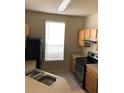 Bright kitchen featuring neutral countertops, cabinets, and a window at 9061 Lee Vista Blvd # 1303, Orlando, FL 32829
