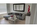 Stylish living room with modern decor, including a plush gray sectional sofa and mirrored coffee table at 10197 Ridgebloom Ave, Orlando, FL 32829