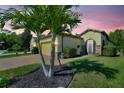 Beautiful home with a well manicured lawn and lush landscaping, including mature palm trees at 104 La Cresta Ct, Davenport, FL 33837