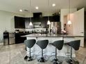 Modern kitchen featuring granite countertops, stainless steel appliances, and an island with bar seating at 14049 Millington St, Orlando, FL 32832