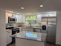 Well-lit kitchen features stainless steel appliances, granite countertops, and a functional island at 1539 Roselawn Sw St, Winter Haven, FL 33880