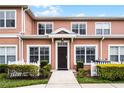 Charming townhome exterior with tidy landscaping, a picket fence, and a welcoming front door at 2200 San Vittorino Cir # 105, Kissimmee, FL 34741