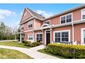 Two story townhome features tidy landscaping, a picket fence and covered front porch at 2200 San Vittorino Cir # 105, Kissimmee, FL 34741