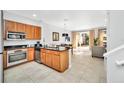 Bright, modern kitchen with stainless steel appliances, granite countertops, wooden cabinets, and an open dining area at 2619 Corvette Ln, Kissimmee, FL 34746