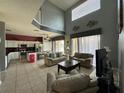 Bright and airy living room featuring high ceilings, tile floors, and an open floor plan to the kitchen at 2677 Emerald Island Blvd, Kissimmee, FL 34747