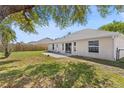 Spacious backyard with a grassy area, concrete patio, and view of the home's exterior at 2804 Latter Day Ct, St Cloud, FL 34769